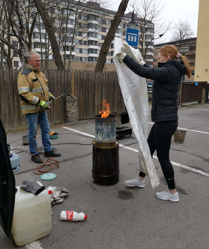 Omenan siivoushenkilökunta harjoittelee sammutuspeitteen käyttöä.