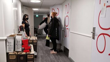 Omenan toimitusjohtaja Kati niemelä keskustelee uuden Porin Omena-hotellin siivoustiimin kanssa hotellin käytävällä.